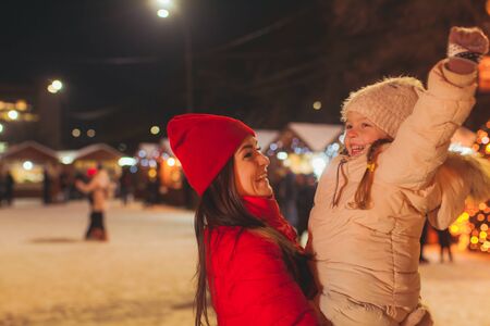 Close view of girl and woman outdoors at winter fair
