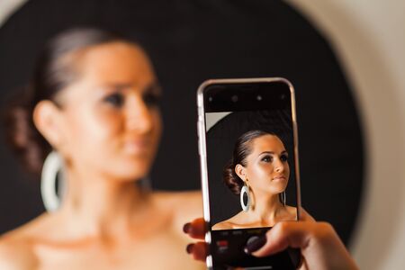 Photo of model on screen of smartphone, taken by makeup artistの写真素材