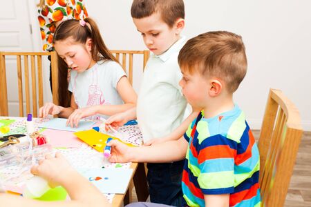Two boys and a girl make lovely postcards in the masterclassの写真素材