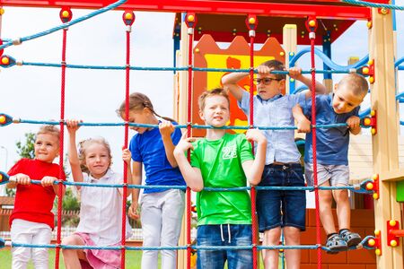 Group of children holding on climbing net