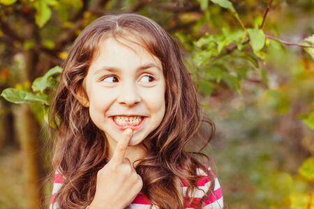 Child pointing recently erupted permanent front tooth