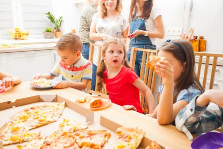 Children eating pizza on the kids party, scandi kitchenの写真素材