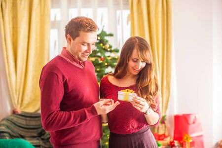 Lovely couple celebrate Christmas. Woman holding presentsの写真素材
