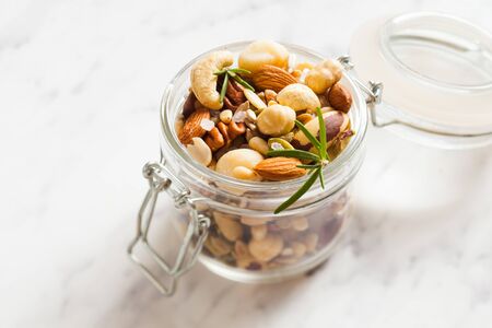 Mix of different types of nuts with salt and rosemaryの写真素材