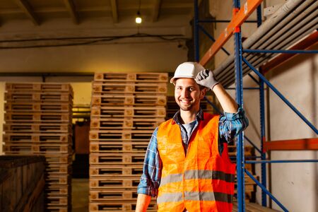 Smiling warehouse workers in protective helmet portrait
