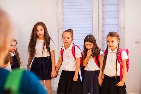 Group of schoolgirls holding hands during break in corridor. School bullying