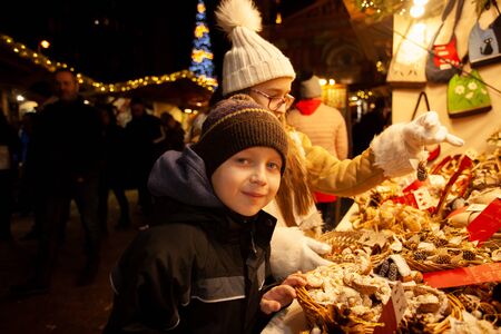 Children choosing souvenir at the christmas marketの写真素材