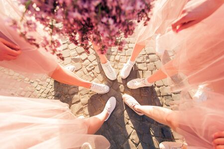 Happy girlfriends making circle with legs top view