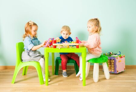 Cute little children playing in kindergarten roomの写真素材