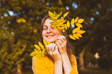 Yellow leaf on the female face in the park