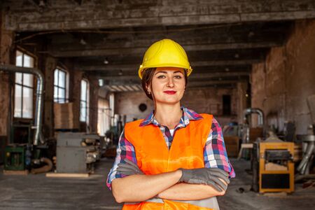 Portrait of woman in hard hat and protective glovesの写真素材