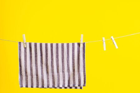 Kitchen towel after washing over yellow background. Mock up for design. Cleaning servicesの写真素材