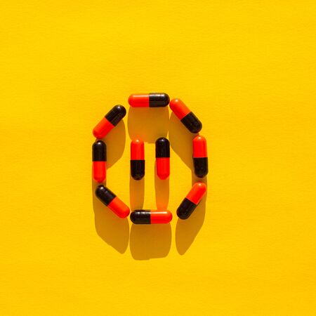 Pills on a yellow background. Pause signの写真素材
