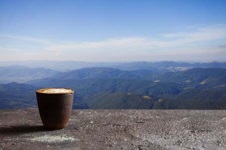 Coffee cup on stone terrace with mountain viewの写真素材