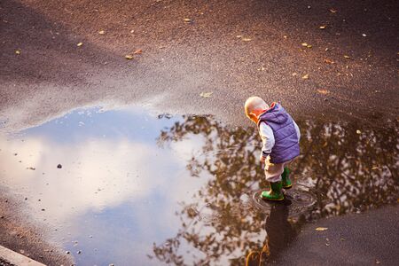 Boy walk in the puddle after the rainの写真素材