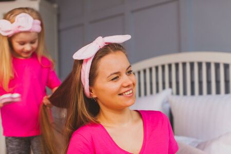 Portrait of lovely mother and cute daughter in bedroomの写真素材