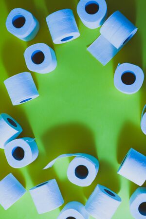 Top view of toilet paper rolls frame on the green background with copy spaceの写真素材