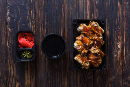 The set of different delicious sushi eel roll with sauce, ginger and wasabi for one person. Top view of sushi on a wooden surfaceの写真素材