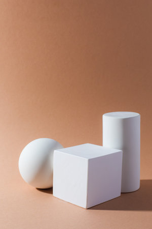 White three-dimensional geometric shapes on light brown background