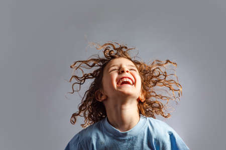 little girl jumps on a gray backgroundの写真素材