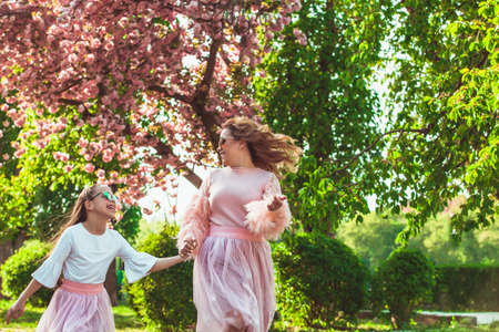mom and daughter are standing next to a tender plant