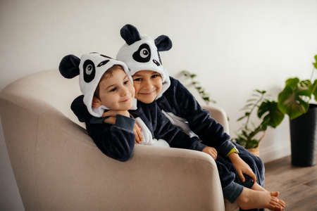 two cute little brothers in kigurumi of pandaの写真素材