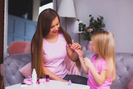 the young mother and daughter are doing manicureの写真素材
