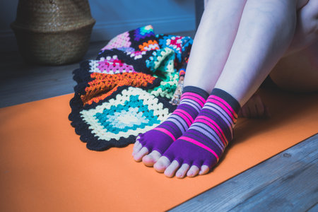 Confident woman in blue sportsuit practicing yoga at homeの写真素材