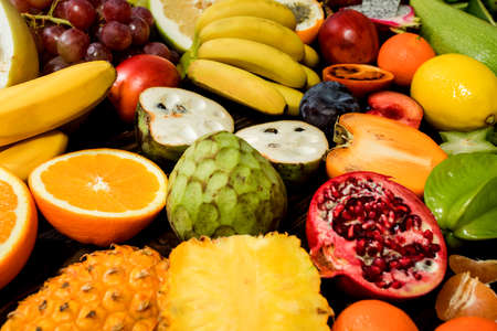 Table with fruit, tropical variety of mixed fruits on wooden backgroundの写真素材
