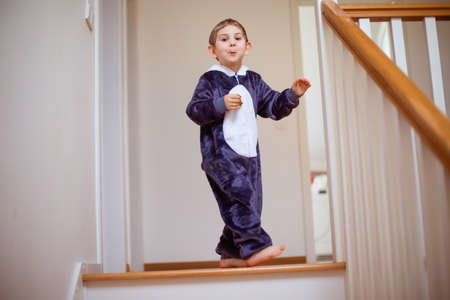 the happy child in kigurumi is resting alone at homeの写真素材