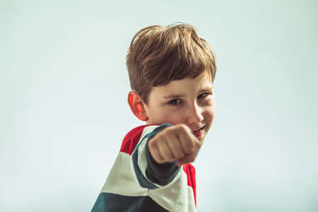 Portrait of young boy in warior pose holding fistsの写真素材