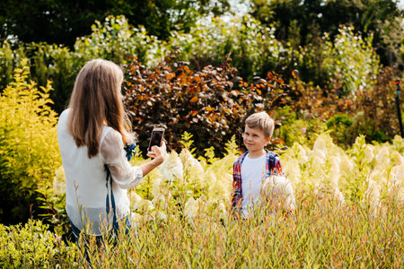 Mother teaches her son to walk in the gardenの写真素材