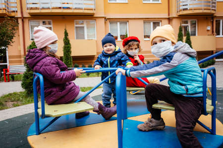 The group of children with a medical masks in a city playgroundの写真素材