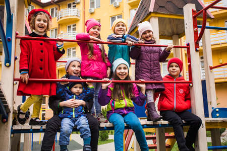the smiling kids are standing together on the playground equipment