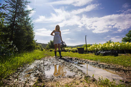 the gardener works in the garden after heavy rain