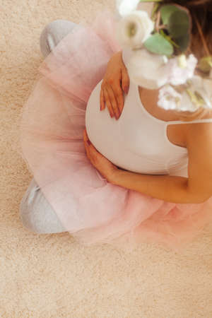 Pregnant woman stay in the room and look at the bellyの写真素材