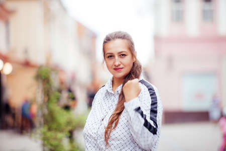 Happy young woman looking around in the cityの写真素材
