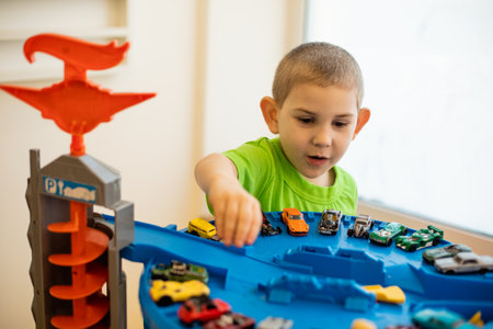 The cute child is playing with toy cars at homeの写真素材
