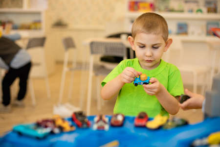 The cute child is playing with toy cars at home