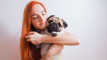 The young woman has a great time with her favorite pugの写真素材