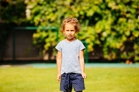 The cute little girl is resting alone in the backyardの写真素材