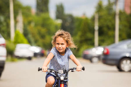 The little girl rides a bike in the cityの写真素材