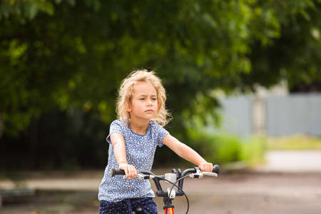 The little girl rides a bike in the cityの写真素材