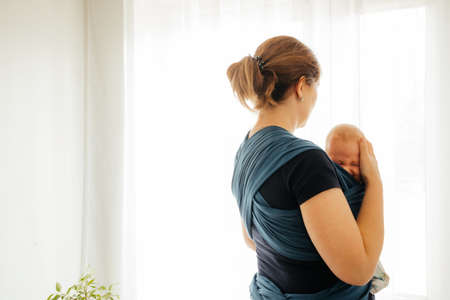 Attachment parenting concept. Young mother with baby in slingの写真素材