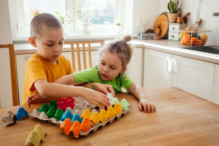 Cute brothers engaged in assembling the paper puzzleの写真素材