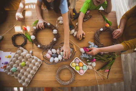 Making homemade Easter wreath of vines decorated with eggsの写真素材