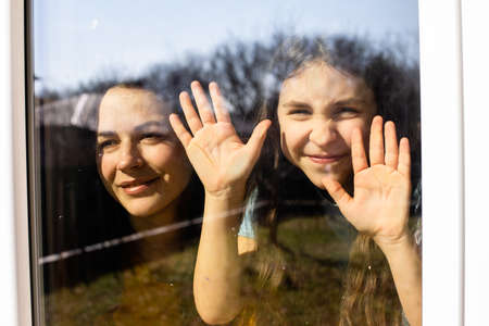 Mom and her daughter admire the beautiful day indoorの写真素材