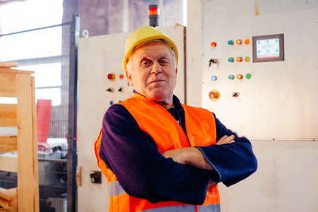 The senior man poses in a production shopの写真素材