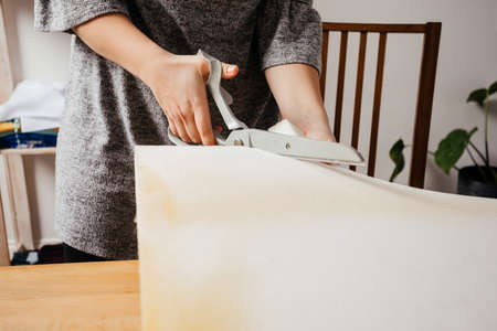 Young adult woman cutting chunk of foam rubberの写真素材