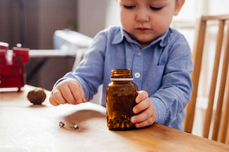 Adorable boy fill metal buttons in the jarの写真素材